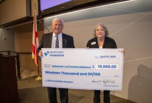 Alzheimer's of Central Alabama Representative accepts check for $19,000 from Southern Energy CU CEO, Derrick Ragland. 